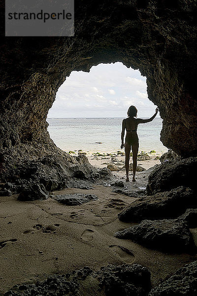 Junge Frau in Höhle  Rückansicht