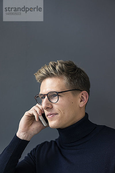 Porträt eines jungen Mannes am Mobiltelefon