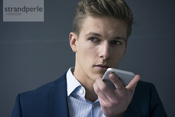 Porträt eines jungen Geschäftsmannes mit Smartphone