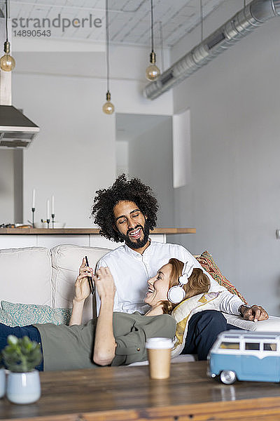 Ein Paar  das sich auf der Couch entspannt und seine Reise plant