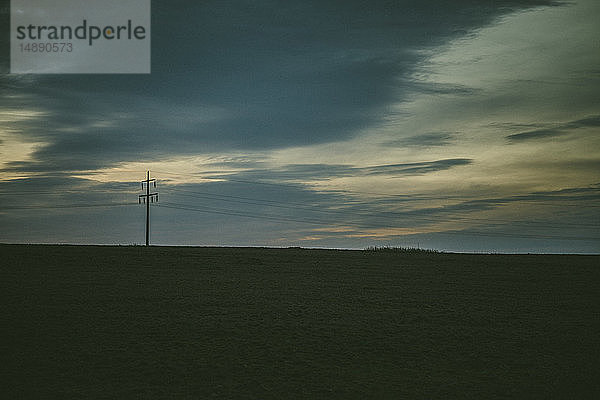 Deutschland  Sylt  Wiese im Abendlicht  Wolken  Tristesse  Strommast