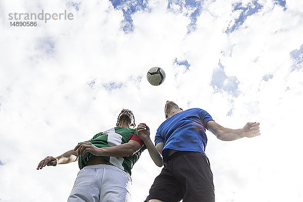 Fussballspieler  die während eines Fussballspiels zum Kopf des Balls springen