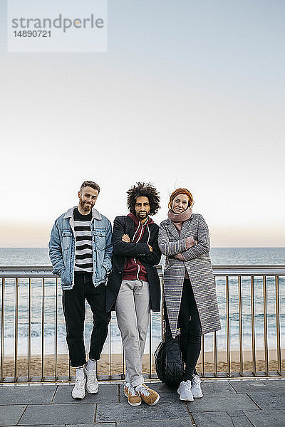 Porträt von drei Freunden am Meer stehend