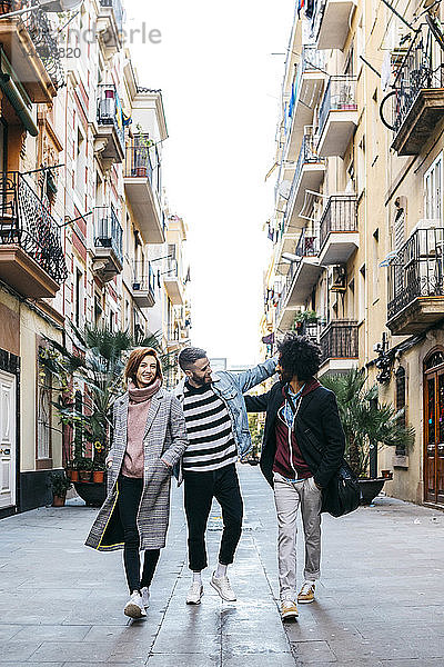 Drei glückliche Freunde spazieren in der Stadt