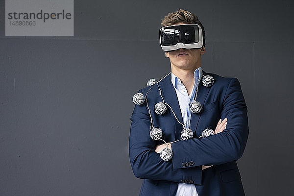 Geschäftsmann mit VR-Brille und Spiegelkugel-Lichterkette