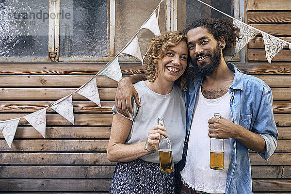 Freunde amüsieren sich auf einer Grillparty  trinken Bier