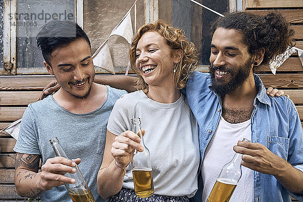 Freunde amüsieren sich auf einer Grillparty  trinken Bier