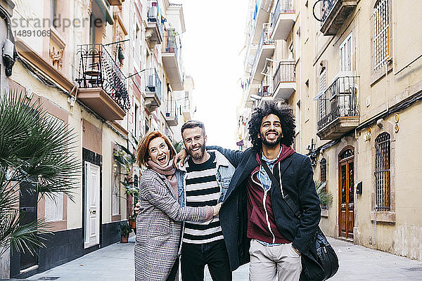 Drei glückliche Freunde spazieren in der Stadt