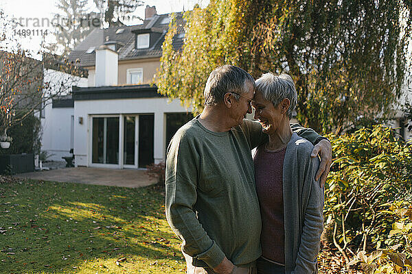 Liebevolles älteres Ehepaar umarmt sich im Garten