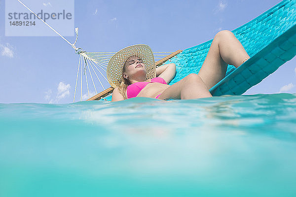 Frau entspannt sich auf einer Hängematte im Meer