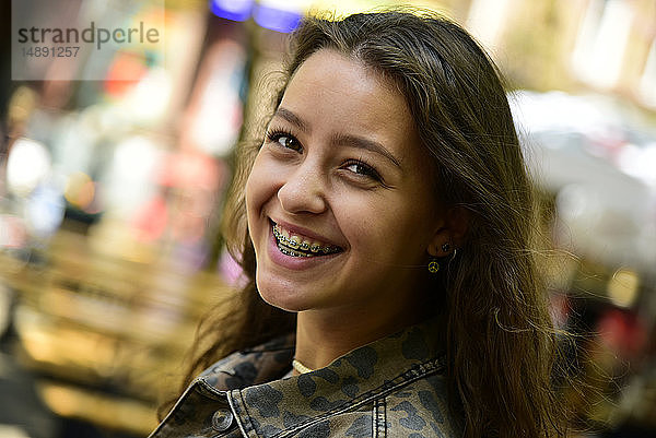 Porträt einer lachenden Teenagerin mit Zahnspange