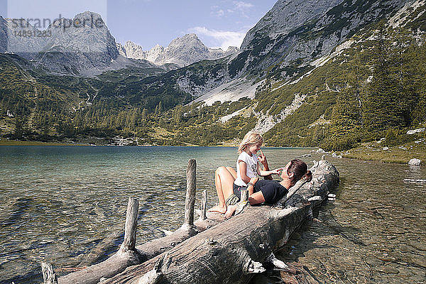 Österreich  Tirol  verspielte Mutter und Tochter auf Baumstamm am Seebensee