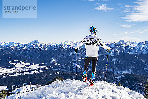 Deutschland  Bayern  Brauneck  Mann im Winter auf Berggipfel stehend