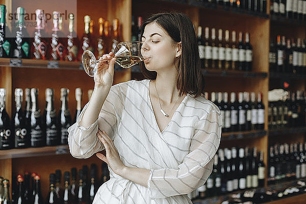 Junge Frau trinkt Weißwein
