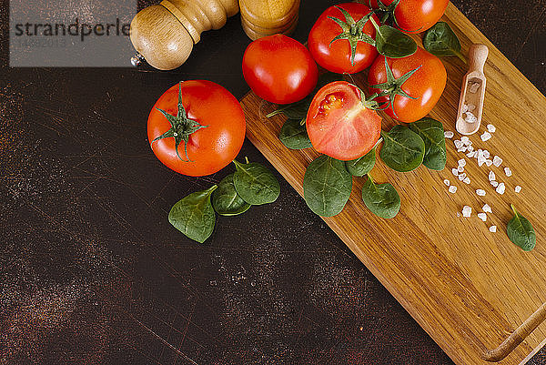 Tomaten  Basilikum und Salz auf einem Holzbrett
