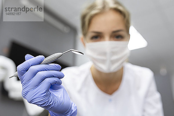 Blick des Patienten auf eine Zahnarzthelferin mit zahnärztlicher Ausrüstung