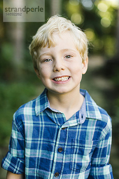 Porträt eines lächelnden Jungen mit kariertem Hemd