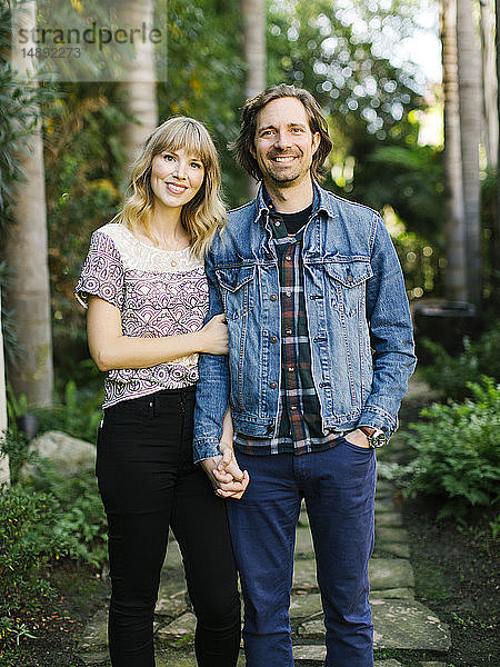 Mid adult couple holding hands in garden