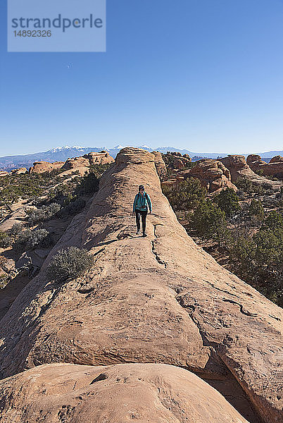 Frau beim Wandern auf einem Felsen im Arches National Park  Utah  USA