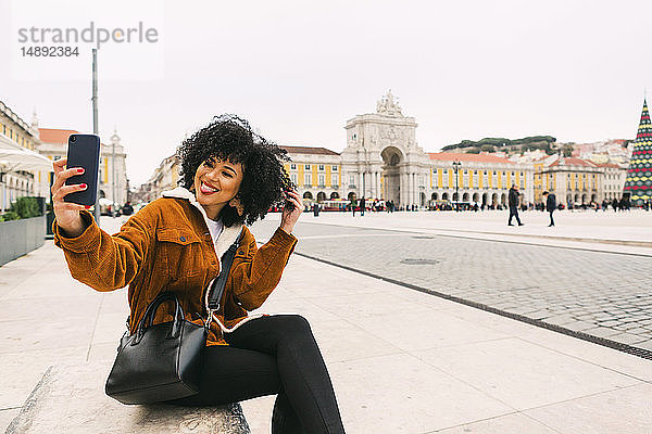 Junge Frau macht ein Selfie auf dem Stadtplatz in Lissabon  Portugal