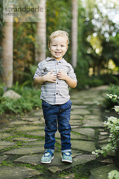 Lächelnder Junge im Garten stehend