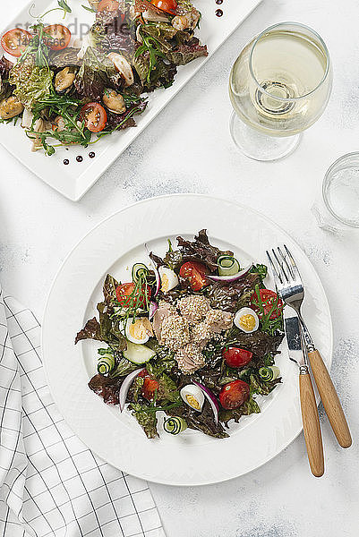 Teller mit Salat und Weißwein