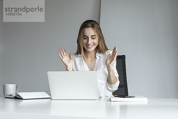 Lächelnde Geschäftsfrau bei der Arbeit am Laptop