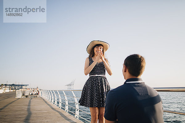 Mann macht Frau auf Seebrücke einen Heiratsantrag