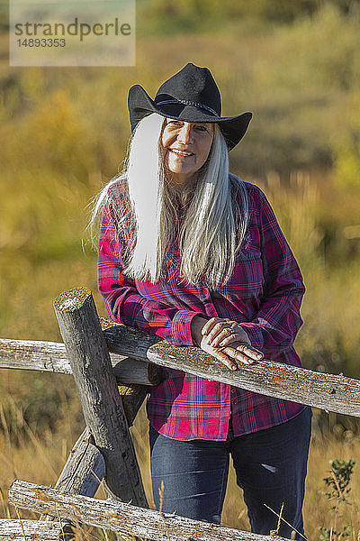 Ältere Frau mit Cowboyhut auf einem Feld