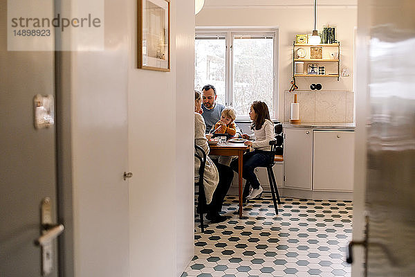 Familie beim gemeinsamen Essen in der Küche zu Hause