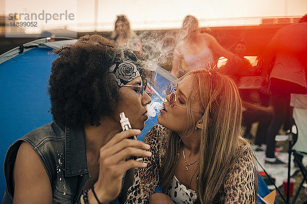 Gemeinsam rauchendes Paar vor dem Zelt bei Musikveranstaltung