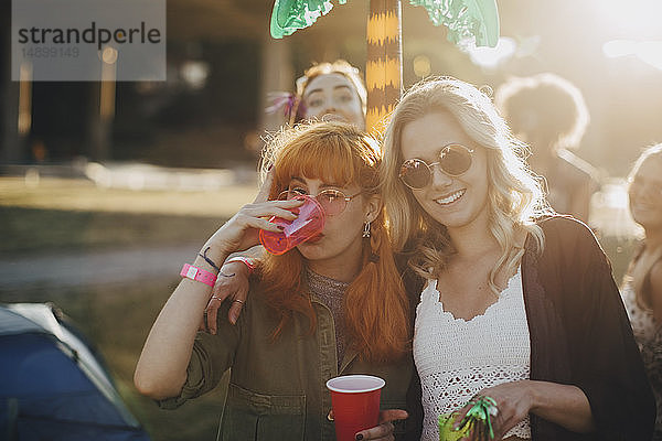 Glückliche Freunde genießen Drinks bei Musikveranstaltung an einem sonnigen Tag