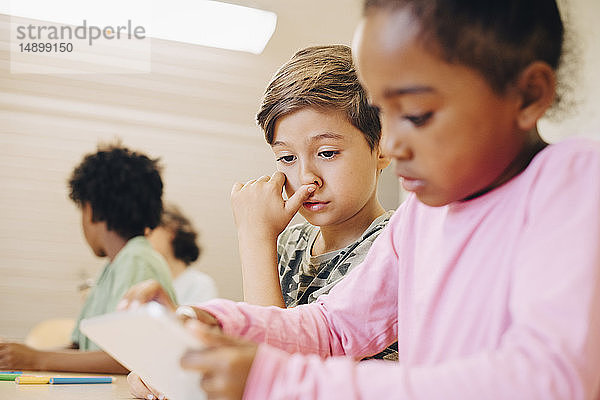 Jungen verwenden digitale Tabletts beim Lernen im Klassenzimmer