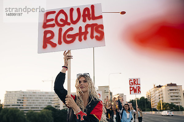 Frauen protestieren mit Freunden für Gleichberechtigung in Stadt gegen Himmel