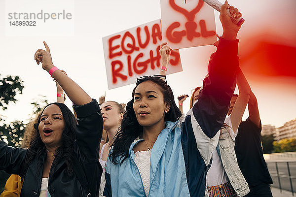 Frauen mit Transparenten  die gemeinsam für gleiche Rechte gegen den Himmel protestieren