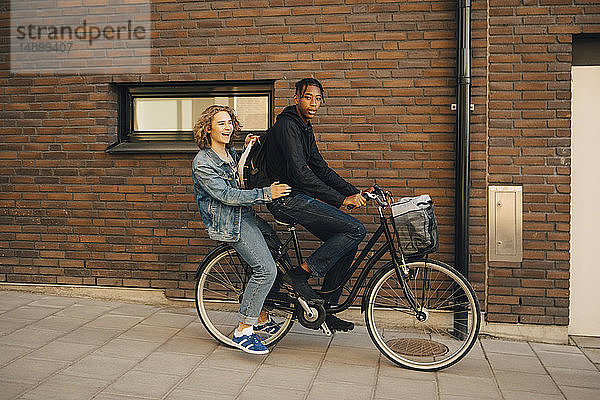 Porträt eines radfahrenden Teenagers mit Freund auf der Straße in der Stadt