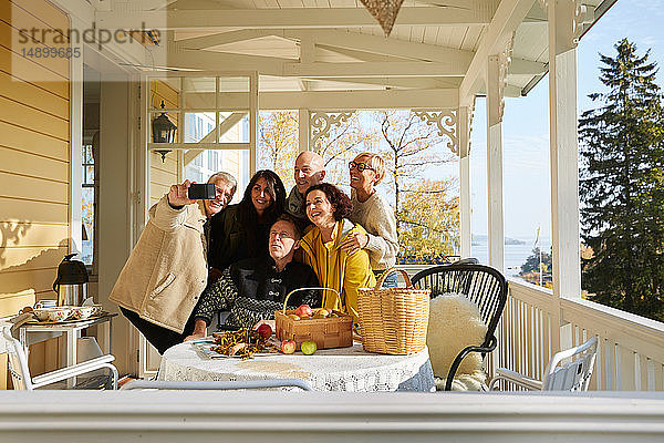 Glückliche reife Freunde posieren für Handy-Selfie auf der Veranda