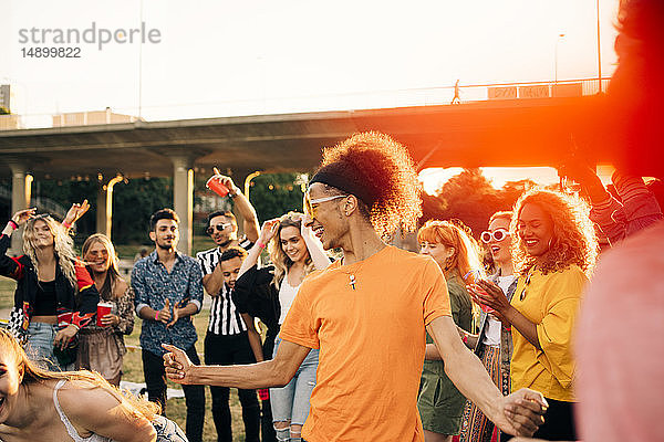 Mann genießt es  im Sommer mit Freunden bei einer Musikveranstaltung zu tanzen