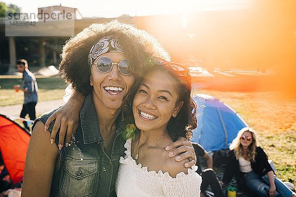 Porträt von lächelnden Freunden  die sich im Sommer am Musikfestival erfreuen