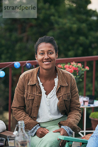Porträt einer lächelnden selbstbewussten Frau  die auf der Terrasse feiert