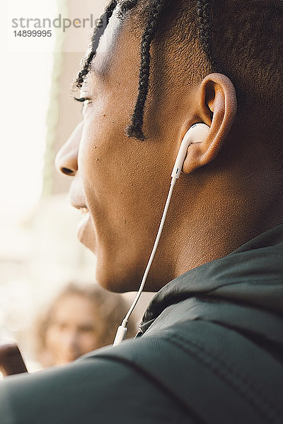 Teenager-Junge hört Musik über Kopfhörer in der Stadt