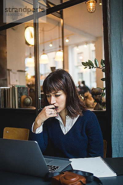 Geschäftsfrau  die am Schreibtisch arbeitet  während sie im Kreativbüro einen Laptop benutzt