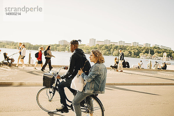 Jugendlicher Junge fährt mit Freund Fahrrad auf der Straße in der Stadt