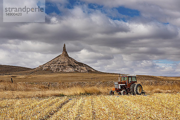 Traktor auf einem Acker und Schornsteinfelsen  Scotts Bluff National Monument; Scottsbluff  Nebraska  Vereinigte Staaten von Amerika