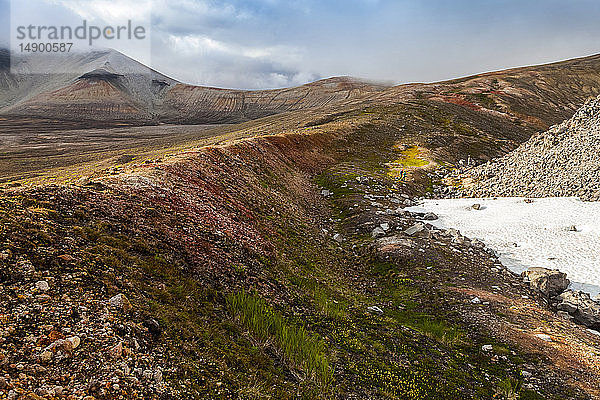 Zwei Rucksacktouristinnen füllen Wasser am Novarupta auf  Broken Mountain im Hintergrund  Katmai National Park and Preserve  Valley of Ten Thousand Smokes  Südwest-Alaska; Alaska  Vereinigte Staaten von Amerika