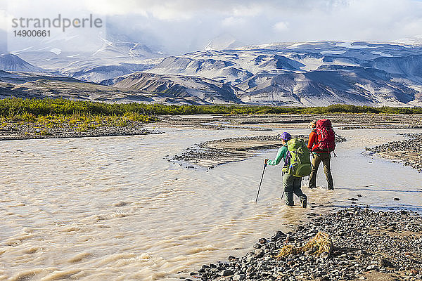 Zwei Rucksacktouristinnen überqueren den Katmai River  Katmai National Park and Preserve  Südwest-Alaska; Alaska  Vereinigte Staaten von Amerika
