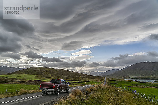 Pickup  der auf einer Straße in den Bergen fährt; Island