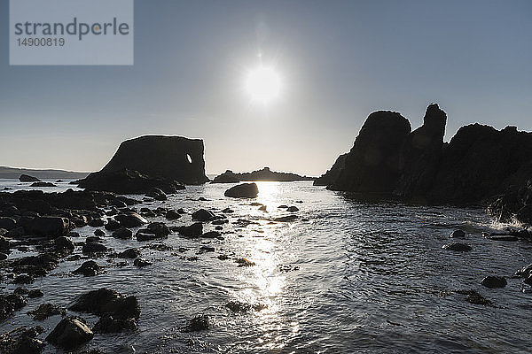 Silhouettierte Felsformationen entlang der Küste; Irland