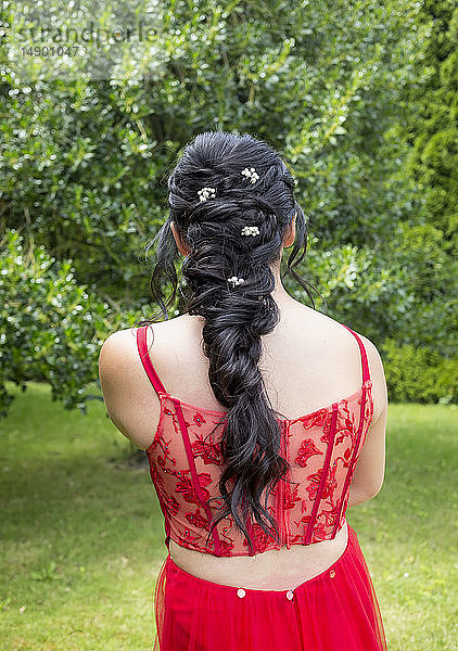 Rückansicht einer jungen Frau in einem roten formellen Kleid mit gestylten langen Haaren; Chilliwack  British Columbia  Kanada