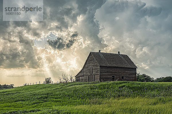 Verlassene Scheune mit zusammenziehenden Gewitterwolken über dem Kopf; Nebraska  Vereinigte Staaten von Amerika